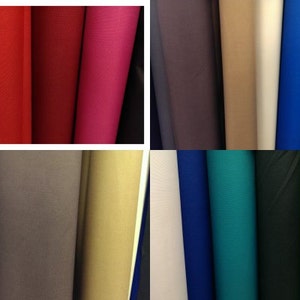 Puede incluir: Una variedad de rollos de tela en diferentes colores, incluyendo rojo, rosa, marr&oacute;n, beige, azul, verde, negro y amarillo.