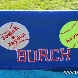 Puede incluir: Un respaldo de silla personalizado azul y rojo con el nombre "BURCH" y dos pelotas de b&eacute;isbol con los nombres "Josiah & Jayden" y "Aryanna" en ellos.