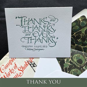 May include: A white greeting card featuring dark green embossed calligraphy that reads: "THANKS and THANKS, and EVER THANKS." Below the text is "TWELFTH NIGHT, III:3" and "William Shakespeare." The card is paired with an envelope featuring a marbled pattern.