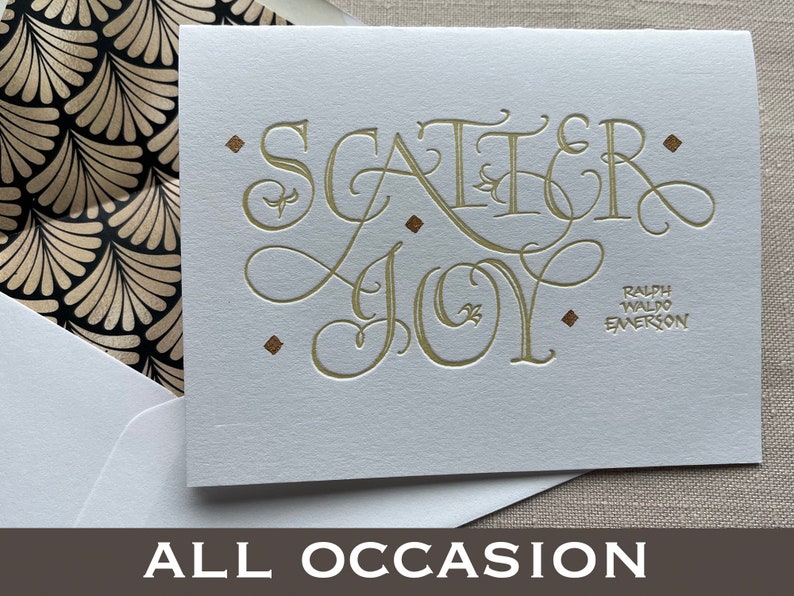 May include: A white card with gold lettering that reads "Scatter Joy" and a quote from Ralph Waldo Emerson. The card is for all occasions.
