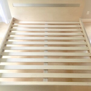 May include: A white wooden slatted bed frame with a simple design.