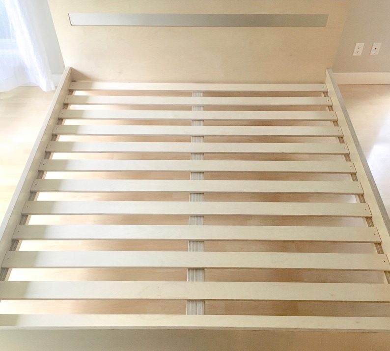 May include: A white wooden slatted bed frame with a simple design.