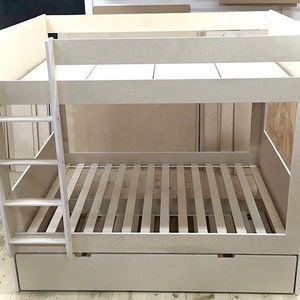 May include: A white wooden bunk bed with a ladder on the side and a pull-out drawer underneath the bottom bunk.