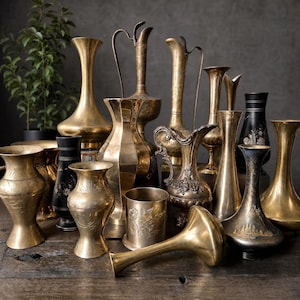 May include: A collection of various brass vases, pitchers, and vessels in different shapes and sizes. The items feature smooth, etched, and embossed surfaces with metallic gold tones, including one black vase with floral details and one lying flat.