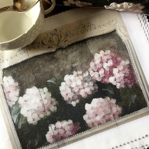 Könnte beinhalten: Ein gerahmter Druck einer Vintage-botanischen Illustration mit rosa und weißen Hortensien mit grünen Blättern. Der Druck ist auf weißem Hintergrund mit einem dekorativen Rahmen.