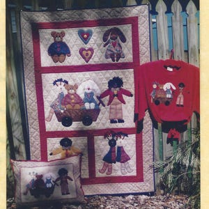 May include: A patchwork pattern featuring a quilt, pillow, and red long-sleeve shirt with toy figures. The quilt has a red border with toy figures. The text "THE PATCHWORK ANGEL" and "THE TOY TROLLEY" are visible.