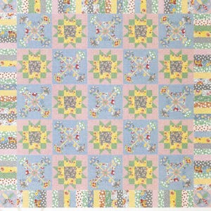 Puede incluir: Un patrón de edredón titulado "Cross My Heart" con un diseño de bloques repetidos. Los bloques alternan entre cuadrados azul claro y rosa, con patrones florales y geométricos en amarillo, verde y gris. El borde superior incluye el texto "Leonie Bateman designs to inspire".