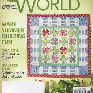 Könnte beinhalten: Ein Magazin-Cover für Quilter's World, ein Magazin für Quilt-Liebhaber. Das Cover zeigt eine farbenfrohe Quiltdecke mit einem weißen Lattenzaun-Design und dem Text "Make Summer Quilting Fun".
