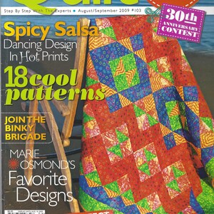 Könnte beinhalten: Ein Magazin-Cover für das Quilt-Magazin, das eine farbenfrohe Quiltdecke mit einem geometrischen Muster zeigt. Der Text auf dem Cover lautet "Spicy Salsa Dancing Design in Hot Prints 18 cool patterns" und "Join the Binky Brigade Marie Osmond's Favorite Designs".