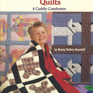 May include: The cover of a book titled "Patchwork Animal Quilts" shows a child wrapped in a patchwork quilt with bear appliqués. The quilt has a black, white, and plaid pattern. The book cover also includes the text "8 Cuddly Comforters."