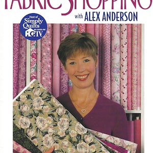 May include: A woman holding a stack of fabric with floral patterns. The fabric is in shades of pink, green, and white. The text on the image reads "FABRIC SHOPPING with ALEX ANDERSON" and "Seven Projects to Help You: Make Successful Choices - Build Your Confidence - Add to Your Fabric Stash".