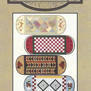 Könnte beinhalten: Vier verschiedene Tischläufer mit saisonalen Motiven. Die Läufer sind oval geformt und zeigen Designs wie eine Wassermelone, ein Schachbrett, eine Patchworkdecke und einen Schneemann. Der Text "More Seasonal Table Runners #822" befindet sich am unteren Rand des Bildes.