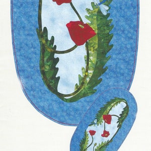 Puede incluir: Un patrón de acolchado con un fondo azul y un patrón de remolino blanco. El patrón tiene forma ovalada y presenta un diseño de flores de amapola rojas con hojas verdes. El texto "Windy Days #0375" está impreso debajo del patrón. El texto "a little more effect pattern company" está impreso debajo del patrón.