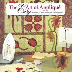 Puede incluir: Un libro titulado "The Art of Appliqué" con el subtítulo "Técnicas fáciles para el aplique a mano, a máquina y fusible". La portada presenta un edredón con diseños florales. También se ven una plancha, una máquina de coser, retales de tela y unas tijeras.