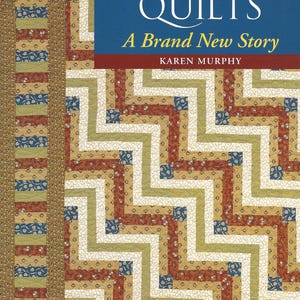 May include: A book titled Log Cabin Quilts: A Brand New Story by Karen Murphy. The cover features a quilt pattern with zigzagging lines in red, tan, blue, and white fabric squares. A vertical border of patterned fabric runs along the left side.