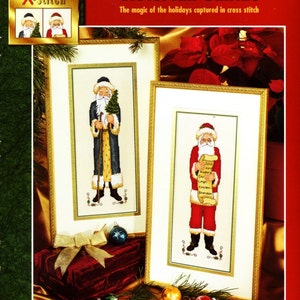 May include: A cross stitch pattern featuring two Victorian Santas. One Santa is holding a Christmas tree and the other is holding a scroll with a list of names. The pattern is framed in gold and has a red background. The design size is 11 inches by 20 inches (27.94 cm x 51 cm). The frame size without the mat is 6.5 inches by 15.5 inches (16.5 cm x 39.4 cm).