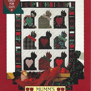 Può includere: Un modello di trapunta con nove silhouette di gatti neri con cuori in patchwork rosso, verde e bianco. La trapunta è intitolata "Crazy for Cats II" ed è un modello di "Mumm's The Word".