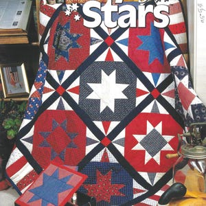 May include: A quilt with a star pattern in red, white, and blue, with the text "Galaxy of Stars" at the top. The quilt is displayed with a matching box. The image also includes the text "All-American All-Star Quilt & Box" and "10 star-studded quilting projects!"