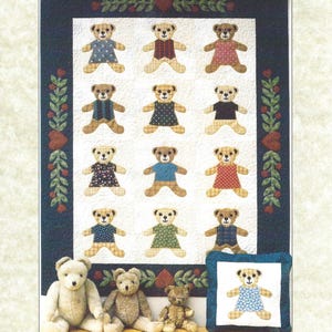 Op de afbeelding: Een quilt met een herhalend patroon van teddyberen met verschillende outfits. De quilt is omrand met een donkerblauwe stof en bloemaccenten. Drie teddyberen en een kussen met een teddybeer staan op de voorgrond. Tekst luidt "Beary Good Friends" en "the Plaid Cat."