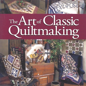 May include: A book titled The Art of Classic Quiltmaking by Harriet Hargrave and Sharyn Craig. The cover features a maroon banner with white text, displaying various interior scenes with patchwork quilts, a wooden rocking chair, and furniture.