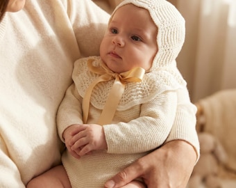 Romper and bonnet for newborn made of 100% merino wool with mother-of-pearl buttons.