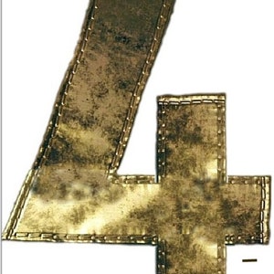 Op de afbeelding: Een goudkleurig metalen nummer vier met een verweerde afwerking. Het nummer is omrand met een gestikte rand.