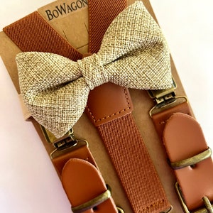 May include: A set of brown suspenders with leather adjustable straps and a matching brown and beige bow tie. The suspenders have a woven texture and the bow tie is made of a burlap-like material. The set is packaged on a brown cardboard backing with the word "BOWAGON" printed on it.