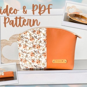 Könnte beinhalten: Eine Kosmetiktasche aus floralem und orangefarbenem Stoff mit Reißverschluss und einem goldenen Etikett mit der Aufschrift "Made with Love".