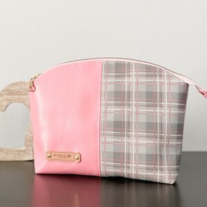 May include: Pink and gray plaid cosmetic bag with a zipper closure and a gold metal tag that says "Handmade with Love".