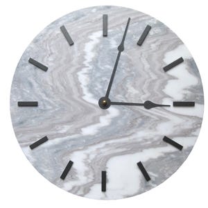 May include: A round wall clock featuring a white and gray marbled stone face with a swirling pattern. The clock has twelve thin, black rectangular hour markers and two slender black hands pointing to approximately three o'clock.