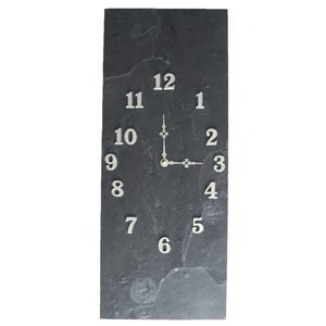 May include: A rectangular wall clock made of dark gray slate. The clock face features white numerals and hands, indicating the time. The clock's design is simple and modern, suitable for various interior styles.