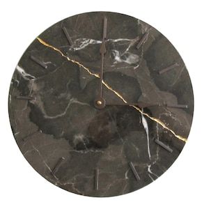 May include: A round wall clock with a dark green marble face and gold veining. The clock has dark metal hands and rectangular hour markers. The clock face is approximately 12 inches in diameter.