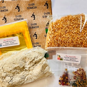 May include: Four clear plastic bags containing craft supplies. The bags contain gold leaf, tan colored powder, small tan and red rhinestones, and small gold and red rhinestones. The bags are labeled with the text "Shri Arts & Gifts" and "Tanjore Gold Foils" and "Tanjore Stones Pack".