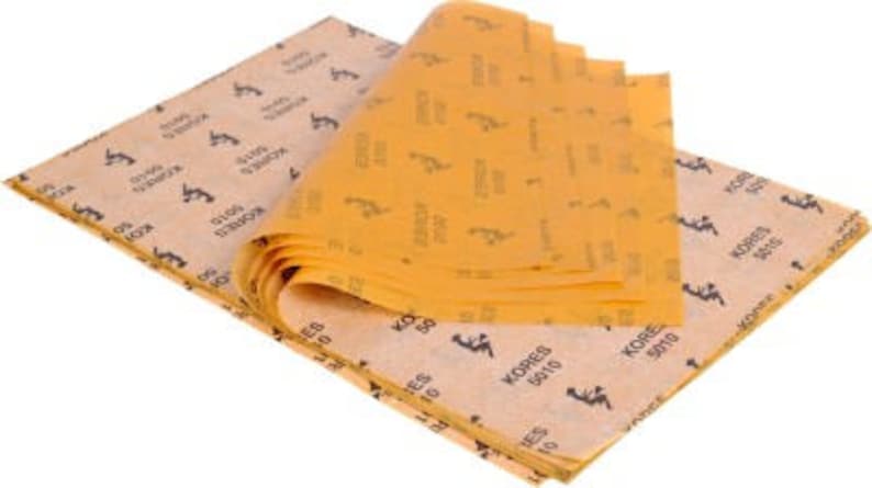 May include: A stack of brown tissue paper with a yellow pattern and the text "KORES 9010" printed on it.