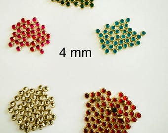 Puede incluir: Una variedad de gemas redondas de 4 mm en varios colores, incluyendo verde, rojo, azul, dorado y rojo oscuro. Cada gema está engastada en una base de metal color oro. Las gemas están dispuestas en pequeños grupos sobre un fondo blanco.