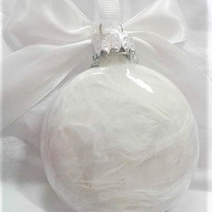 May include: White glass Christmas ornament with a white satin ribbon and bow. The ornament has a textured, feathery design.
