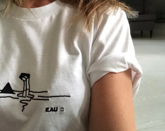 E A U 'Girl and Shark' design, machine embroidered onto 100% cotton American Apparel T-shirt
