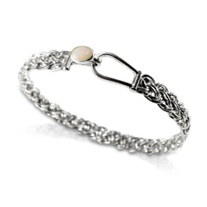 May include: A silver bracelet with a braided chain design and a white opal gemstone accent. The bracelet has a hook clasp.
