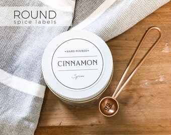 May include: A set of round spice jars with white labels. The labels have black text and say "Cinnamon", "Oregano", "Rosemary", "Himalayan Salt", "Sesame Seed", "Basil", "Dill", and "Garlic Powder".