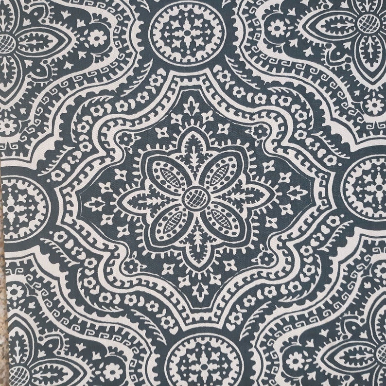May include: A dark blue fabric with a white paisley pattern. The pattern features intricate details and a repeating design.