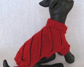 May include: A red knitted dog sweater with a ribbed collar and a diagonal pattern. The dog sweater is designed to fit a small dog and is made of a soft, warm material.