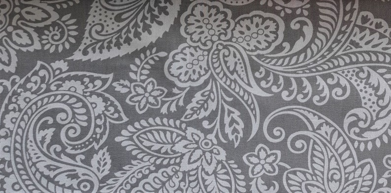 May include: A gray fabric with a white paisley pattern. The pattern features intricate swirls and floral designs.