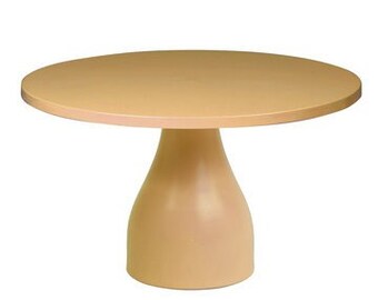 May include: A round, light brown cake stand with a wide, flat top and a flared base.