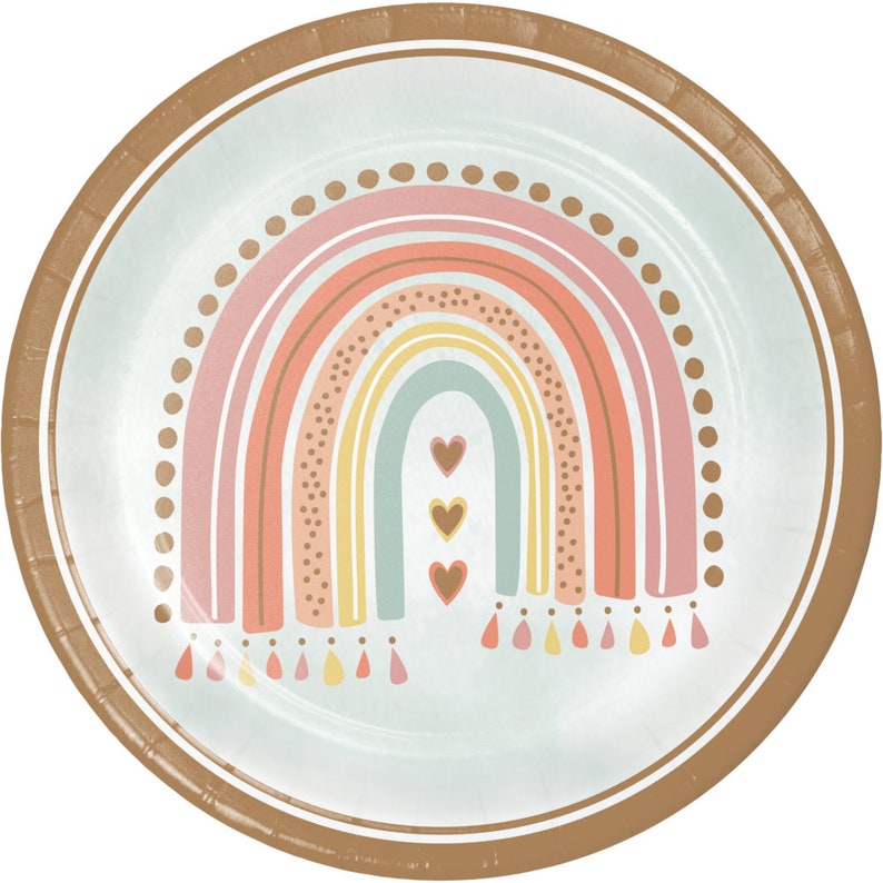 May include: Pastel rainbow design paper plates with a brown border. The rainbow has a light blue, yellow, orange, and pink color scheme. There are three white hearts in the center of the rainbow. The bottom of the rainbow has a fringe design in pink, orange, and yellow.