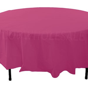 May include: A round, pink plastic tablecloth. The tablecloth is draped over a table with black legs.