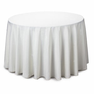 May include: A white, round tablecloth. The fabric drapes to the floor, creating soft folds. The tablecloth is made of a smooth, opaque material, suitable for formal events or everyday use. The table covering is a solid white color.