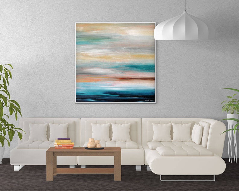 May include: A white sectional sofa with a wooden coffee table and a painting of an abstract seascape above it. The painting features shades of blue, green, and brown.
