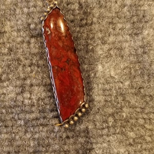 This is Ruby beads and Sterling Silver with a pendant of Dinosaur Bone