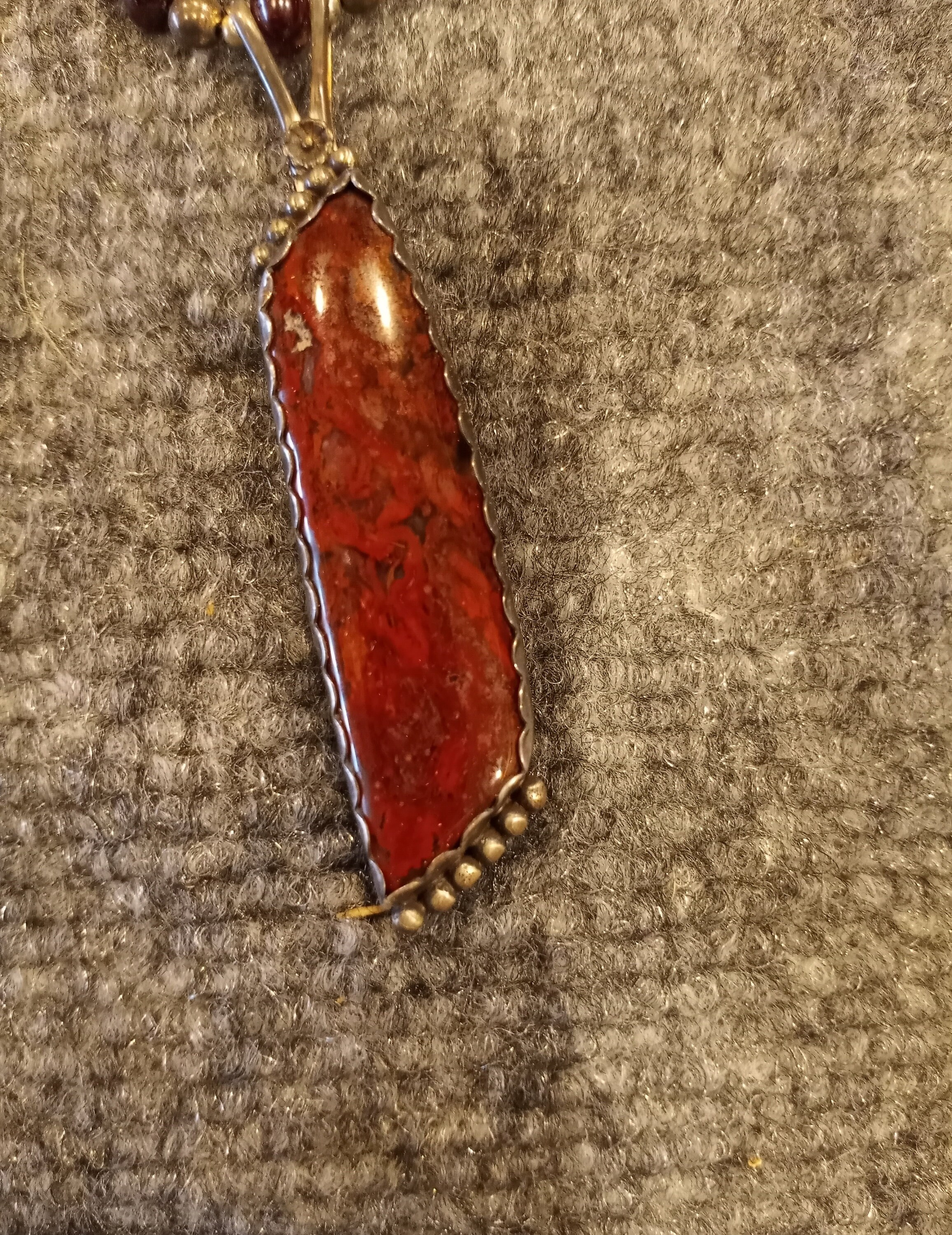 This is Ruby beads and Sterling Silver with a pendant of Dinosaur Bone