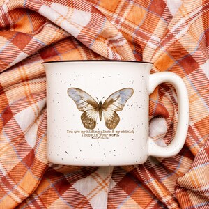 May include: White ceramic mug with a black rim and handle. The mug features a butterfly illustration and the text "You are my hiding place & my shield; I hope in your word. Psalm 119:114."